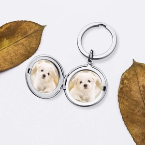 Polished silver round locket keychain featuring two white dog photos in minimalist setting