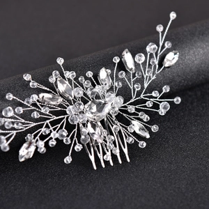 Close-up of bridal hair comb with silver wire, sparkling crystals and leaf shaped rhinestones