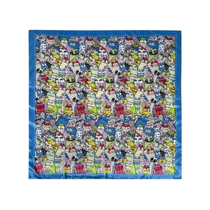 Detailed flat lay of a satin square scarf featuring colorful cartoon cat patterns and blue borders