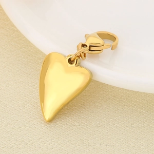 Polished gold-plated 3D heart pendant with sturdy lobster clasp on textured surface