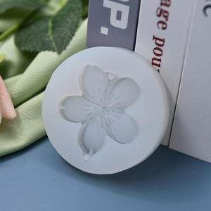 Flower shaped silicone mold for DIY cake baking and soap making on a soft green cloth