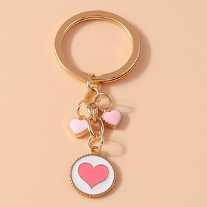 Detailed view of pink enamel heart pendants on a golden metal keychain accessory