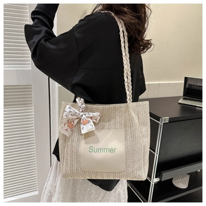 Détail du sac cabas en paille tressée avec anse en foulard et broderie texte Summer