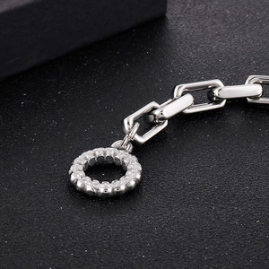 Détail macro des maillons carrés argentés et du fermoir texturé sur un bracelet en acier