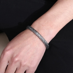 Dettaglio del bracciale rigido vintage argento da uomo con trama a squame di drago