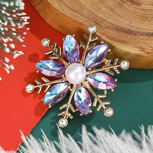 Macro view of crystal flower brooch with center pearl on holiday background