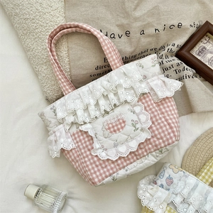 Close-up of pink checkered quilted handbag with lace trim and cute bunny embroidery