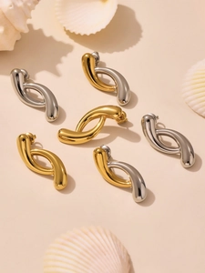 Macro shot of liquid metal drop earrings in gold, silver, and mixed dual-tone finishes