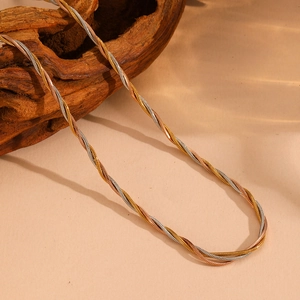Detailed view of 18k gold three-strand braided stainless steel necklace on wood stand