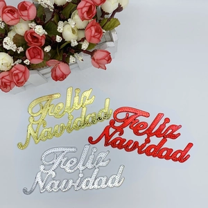 Close-up of gold, red, and silver Feliz Navidad textured ornaments for Christmas decor