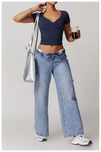 Close-up of navy blue Henley shirt with metal buttons and fold-over waist denim jeans