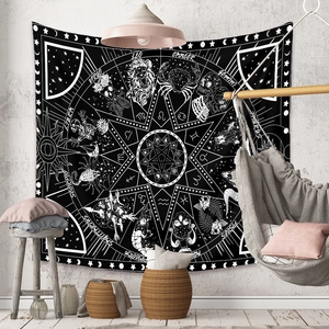 Detail of bohemian tapestry featuring zodiac signs and celestial sun moon patterns