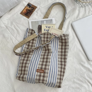 Detail of vintage canvas tote bag with blue stripes and brown checkered patchwork