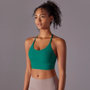 Detail of green halter yoga bra with thin straps and wide hem on a studio model
