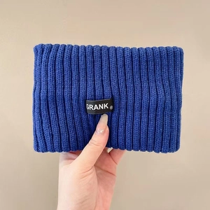 Detail showing dark blue ribbed knit fabric texture and stitched brand logo label