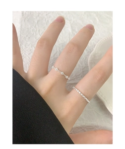 Close-up of S925 sterling silver minimalist rings with floral and beaded textures