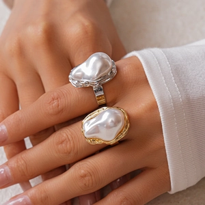 Irregular baroque pearl ring with golden and silver lava metal band worn on hand