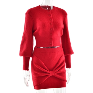 Detail of red knit two-piece set featuring ribbed texture and decorative front bow knot