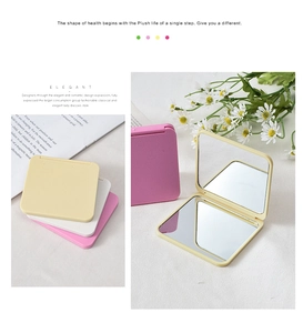 Three colorful folding makeup mirrors in yellow, white, and pink on a soft white cloth
