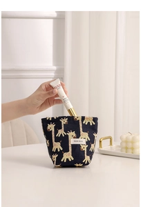 Detail of dark blue giraffe jacquard pouch being used to store small cosmetics