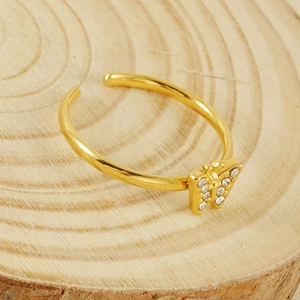 Close-up of a 18K gold butterfly ring with zircons on a wooden texture background
