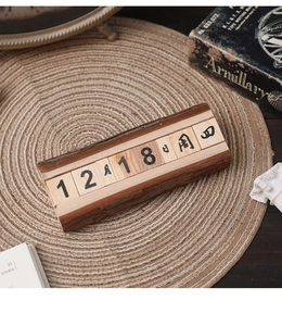 Close-up of vintage wooden perpetual calendar blocks with natural bark edges on rope mat