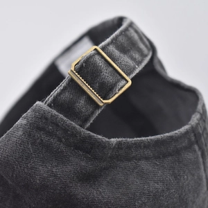 Close-up of washed cotton baseball cap with adjustable metal buckle and fabric strap