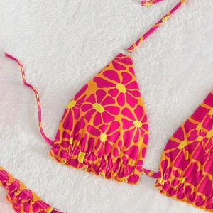 Detailed close-up of floral bikini top with ruffled edges and vibrant retro flower print
