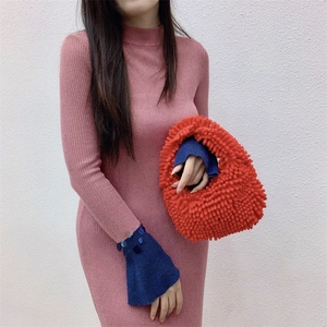 Detail of red plush textured tote bag with curly faux fur and small top handles