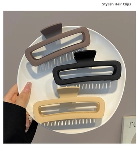 Detailed view of large matte rectangular hair claws in brown, black and beige colors