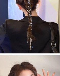 Detail view of silver hair chain with star and snowflake charms woven into a braid