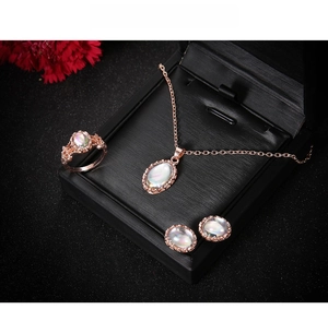 Detail of rose gold jewelry set with iridescent oval stones in a premium black gift box