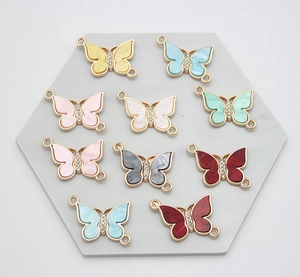 Colorful butterfly alloy charms with rhinestones and pearlescent inlay on a display