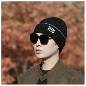 Close-up of black ribbed knit beanie with grey stripes and NY&JA fashion brand label