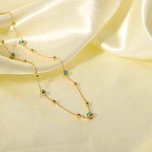 18K gold plated stainless steel necklace with evil eye beads on yellow silk fabric