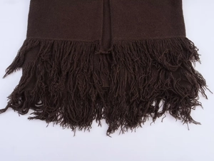 Detail of dark chocolate knit coat featuring thick wool texture and long fringe hemline