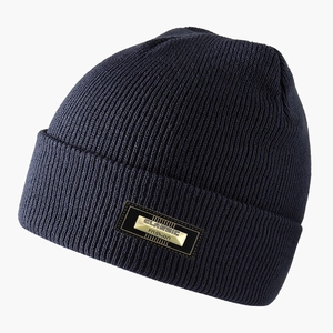 Dettaglio del berretto in maglia a coste blu navy con placca in metallo dorato