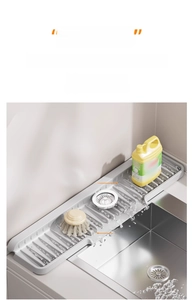 Detail of grey silicone sink mat with drainage ridges and slope for kitchen water runoff