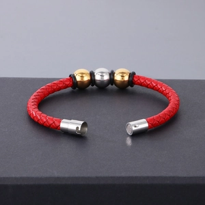 Close-up of red braided leather bracelet with three-tone beads and magnetic clasp detail