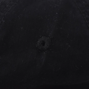 Détail macro des œillets brodés sur la casquette de baseball en coton noir délavé
