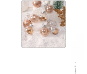 Detail of clear Christmas baubles filled with gold sequins on white artificial snow