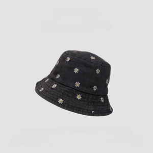 Detail of white daisy embroidery on a black denim sun hat with a minimalist design