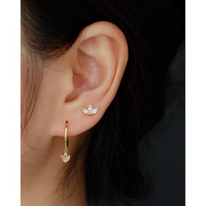 Close-up of golden S925 silver stud and hoop featuring leaf designs with clear cubic zirconia