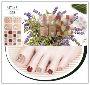 Detail of waterproof gold-stamped toe nail stickers with red and gold pearl accents