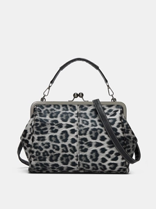 Detail view of leopard print handbag with vintage kiss-lock closure and shoulder strap
