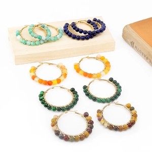 Detail view of handmade wire-wrapped round hoop earrings with colorful natural stone beads