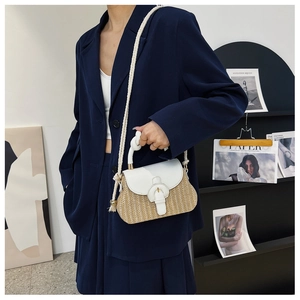 Detail of summer straw crossbody bag with white leather flap and knotted rope handle design
