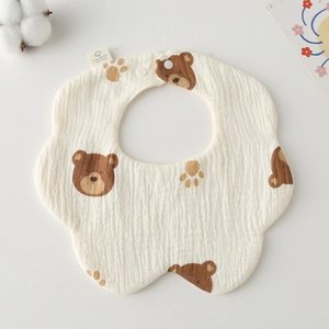 Detailed macro of a soft gauze cotton baby bib featuring brown bear and paw prints