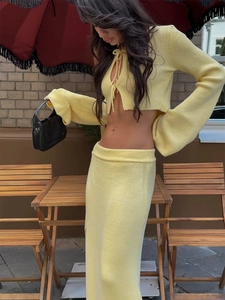 Detail of light yellow knit set featuring tie-front cardigan and flared sleeve texture