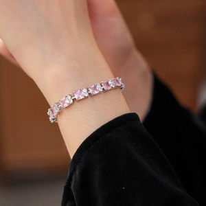 Detalle de pulsera de circonitas rosas cuadradas con engaste de garras en la muñeca